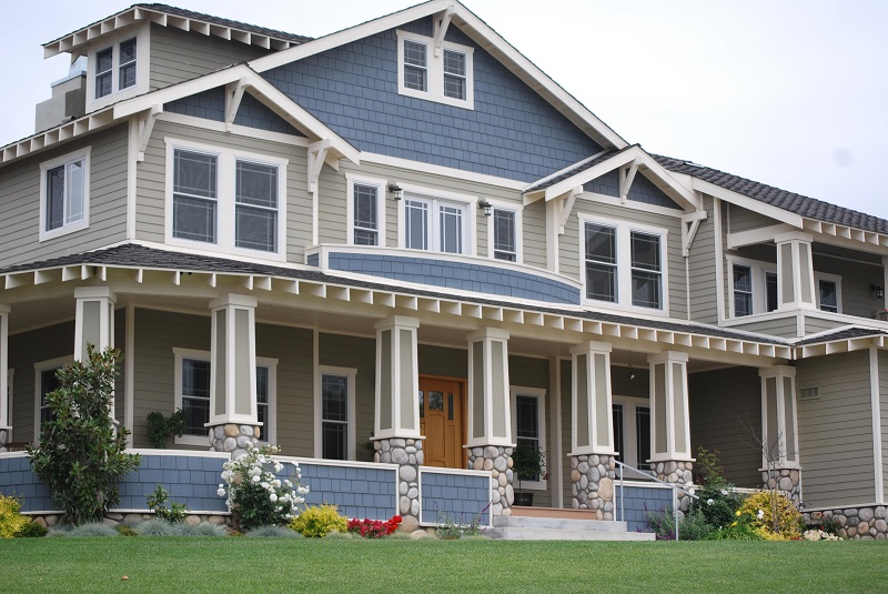 large blue two story home with landscaping